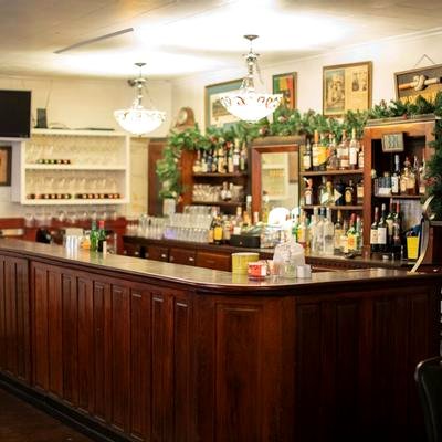 The wood-paneled bar at Mosca's, glasses lined beneath the shelf of bottles